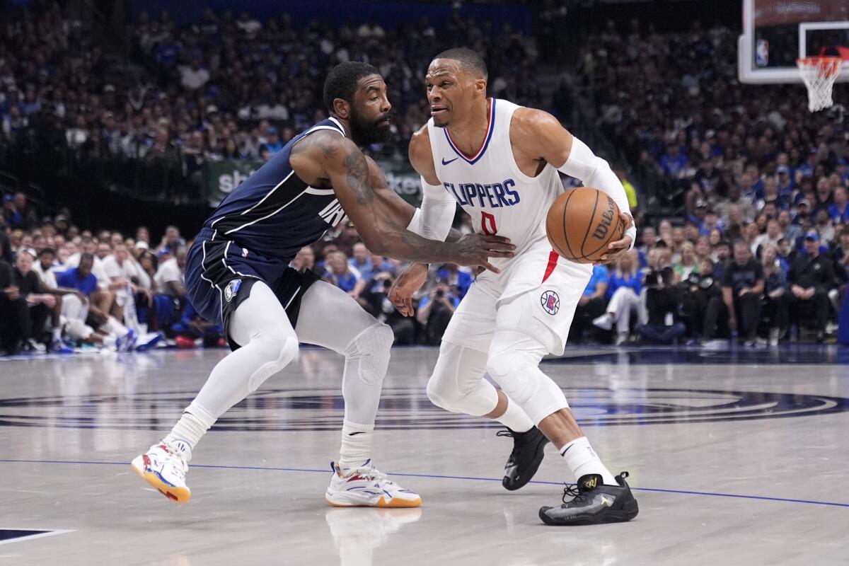 Clippers guard Russell Westbrook, right, tries to drive past Dallas Mavericks guard Kyrie Irving.