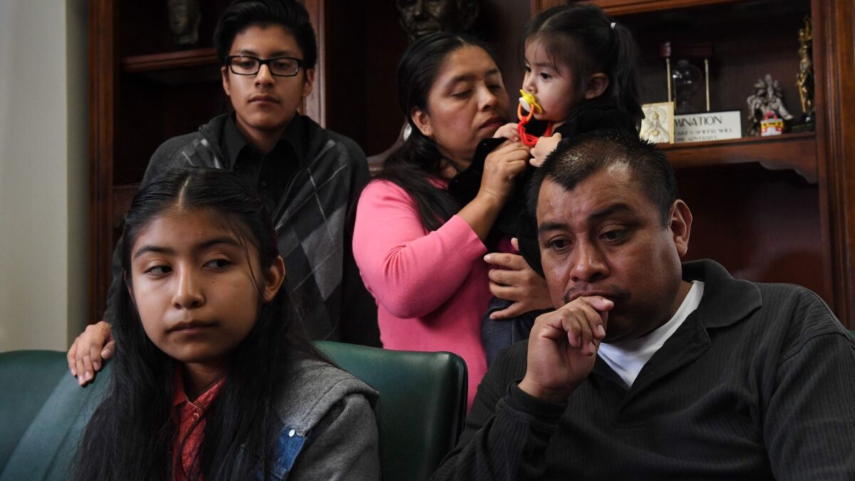 Immigrant Mario Vargas waits with his wife, Lola, and their daughter Athena in their attorney's office before Mario's deportation hearing.