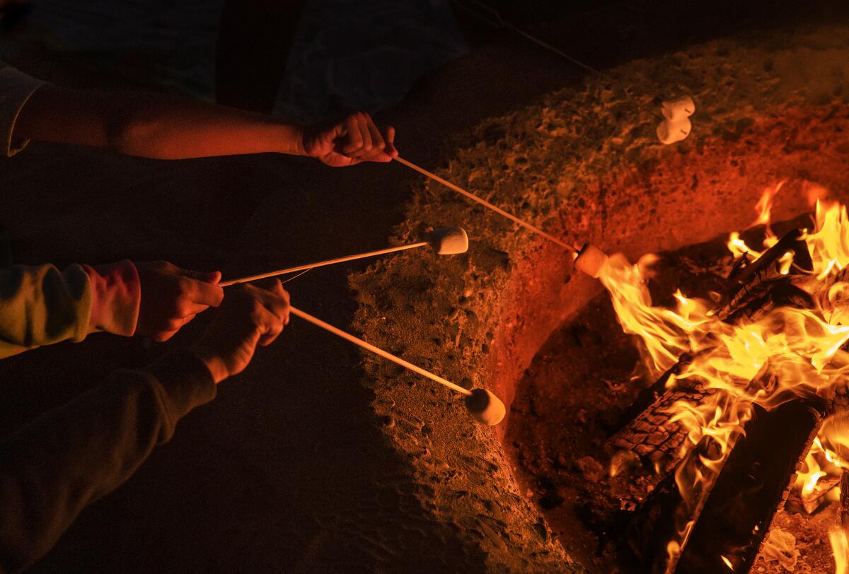 Anak-anak memanggang marshmallow di atas api unggun di Pantai Dockweiler di El Segundo
