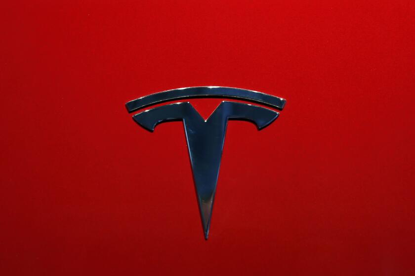 FILE- The logo of Tesla model 3 is seen at the Auto show on Oct. 3, 2018, in Paris. Tesla delivered its first electric semis to PepsiCo Thursday, Dec. 1, 2022, more than three years after Elon Musk said the company would start making the trucks. (AP Photo/Christophe Ena, File)