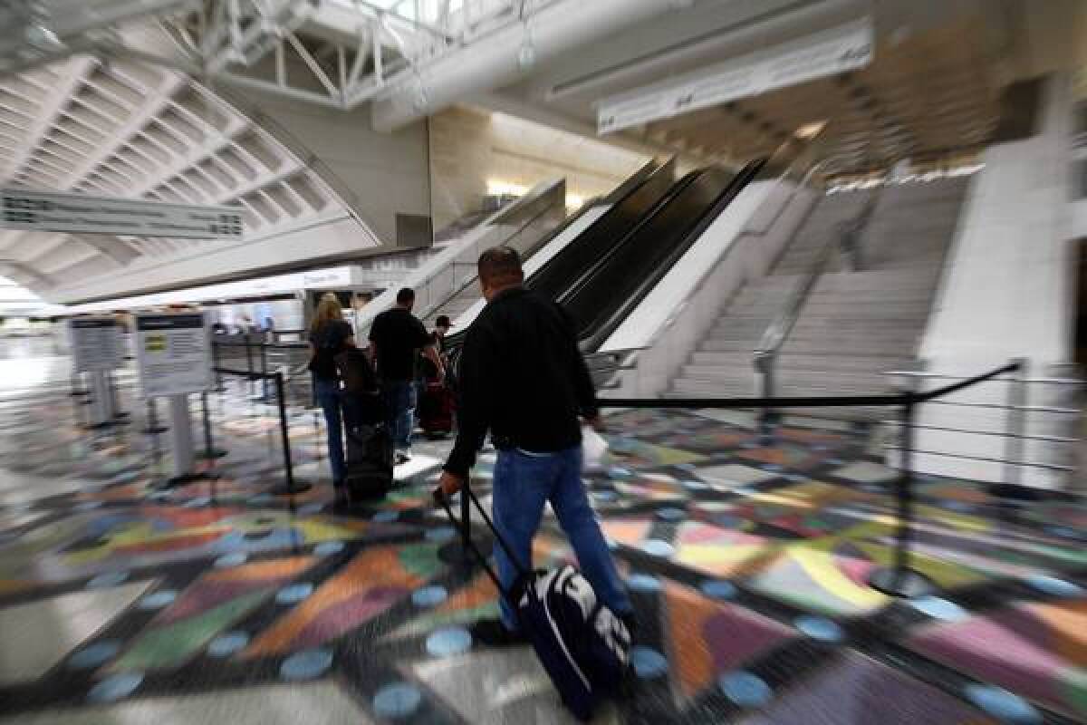 Travelers walk toward the escalators leading to the security check-in point at LA/Ontario International Airport, which has seen a 40% drop in passengers since 2007.