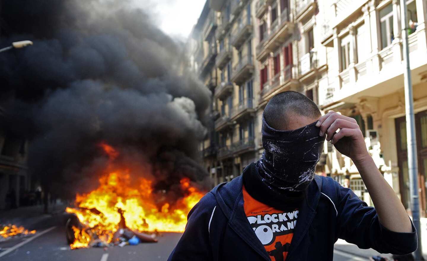 A demonstrator covers his face during the general strike in Barcelona. Spanish unions angry over economic reforms are waging a general strike, challenging a conservative government not yet 100 days old and joining other troubled European workers in venting their frustration on the street.