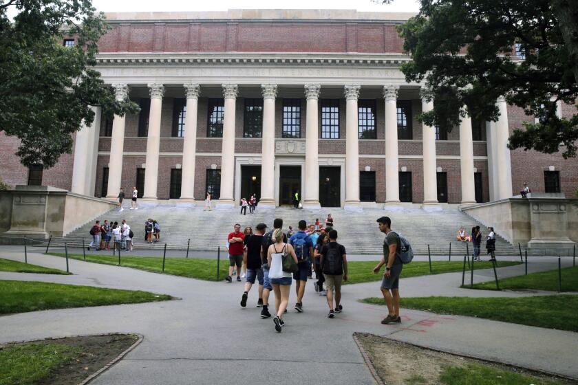 FILE - In this Aug. 13, 2019 file photo, students walk near the Widener Library in Harvard Yard at Harvard University in Cambridge, Mass. The Ivy League school announced Monday, July 6, 2020, that as the coronavirus pandemic continues its freshman class will be invited to live on campus this fall, while most other undergraduates will be required learn remotely from home. (AP Photo/Charles Krupa, File)