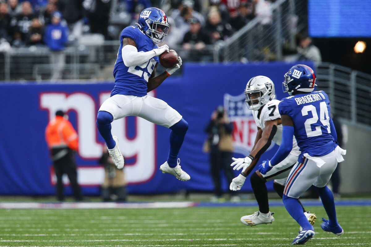 New York Giants free safety Xavier McKinney (29) intercepts a pass intended for Las Vegas Raiders' Zay Jones (7) as Giants' James Bradberry (24) watches during the second half of an NFL football game Sunday, Nov. 7, 2021, in East Rutherford, N.J. (AP Photo/John Munson)