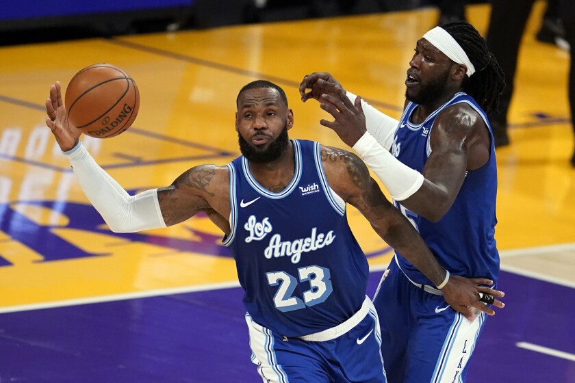 Lakers forward LeBron James grabs a rebound next to center Montrezl Harrell.
