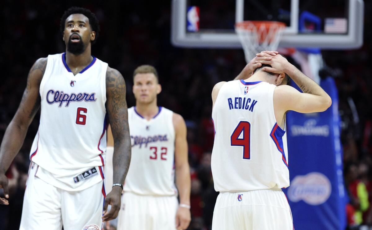 Clippers' J.J. Redick grabs his head in disappointment as teammates DeAndre Jordan (6) and Blake Griffin walk off the court after Redick missed a potential game-tying three-pointer in overtime of Game 2 against the Spurs on Wednesday.