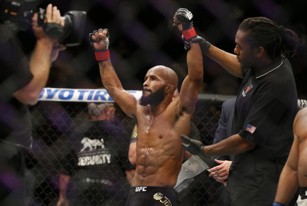 Demetrius Johnson celebrates after defeating John Dodson in their UFC flyweight title bout Saturday in Las Vegas.
