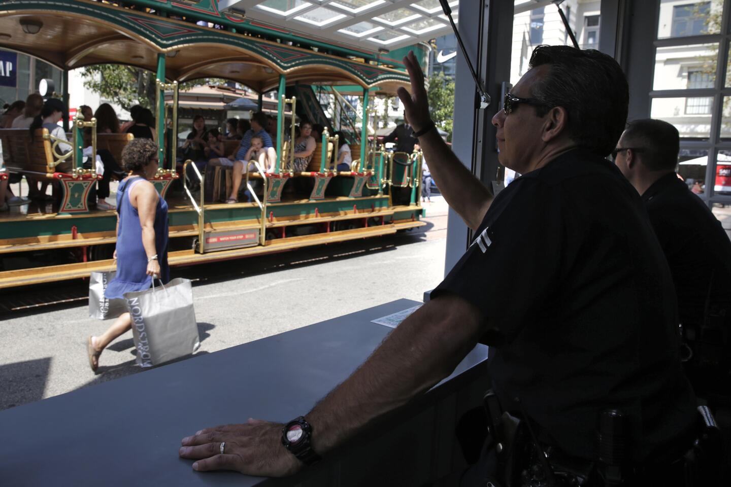Los Angeles Police Officers Michael Acosta, left, and Thomas McClaughlin watch over the Grove shopping center from a police kiosk.