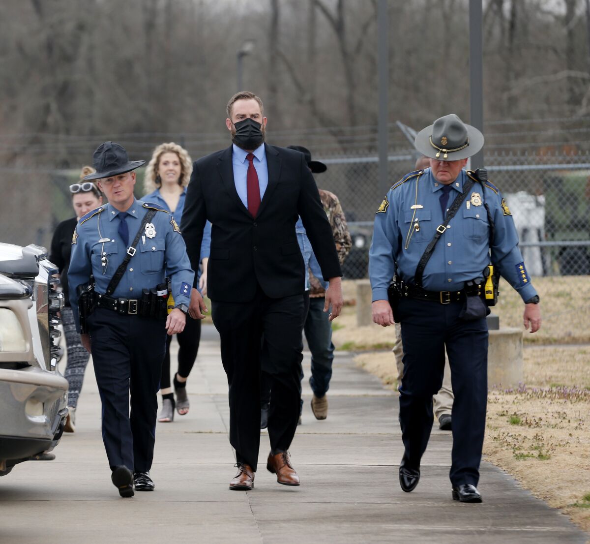 Arkansas State Troopers escort former Lonoke County sheriff's deputy, Michael Davis, center, into the Cabot Readiness Center in Cabot, Ark., on Tuesday, March 15, 2022. A jury was seated Tuesday in the trial of Davis, a former Arkansas deputy charged with manslaughter for fatally shooting a white teenager during a traffic stop, a case that has drawn the attention of national civil rights activists. (Thomas Metthe/The Arkansas Democrat-Gazette via AP)