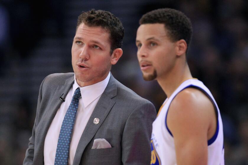 Warriors interim Coach Luke Walton talks to star guard Stephen Curry during a game against the Clippers in Oakland on Nov. 4.