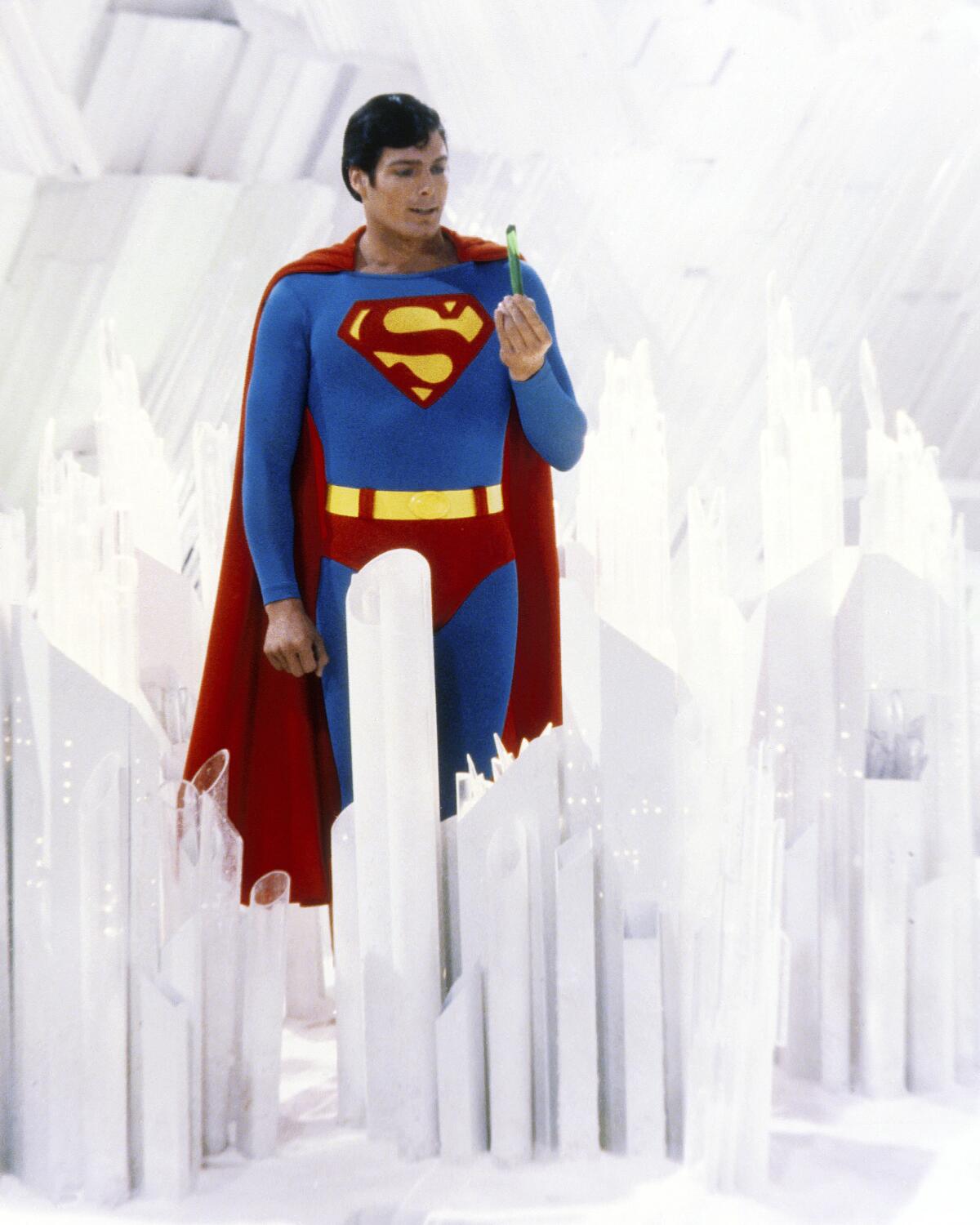 Superman, played by actor Christopher Reeve, holds a green crystal at the Fortress of Solitude.