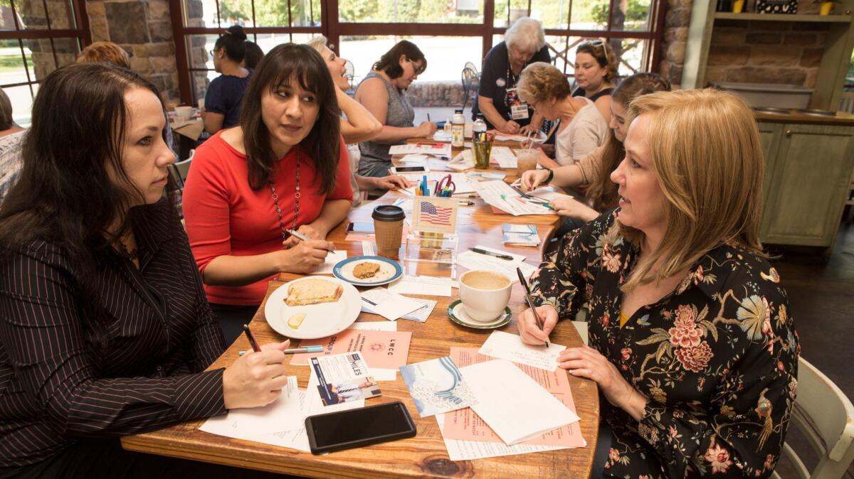 Talking politics, from left, Becky Conner, Sidra Butt and Kim Drew Wright meet with about 20 members of the Liberal Women of Chesterfield County at a local coffee shop in the suburbs of Richmond, Va.