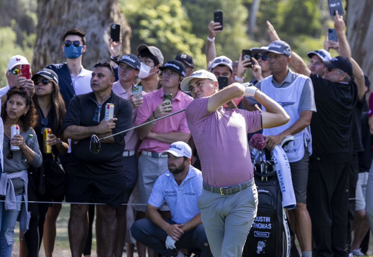 Justin Thomas tees off on the 11th hole as the crowd watches closely during the third round of the Genesis Invitational.