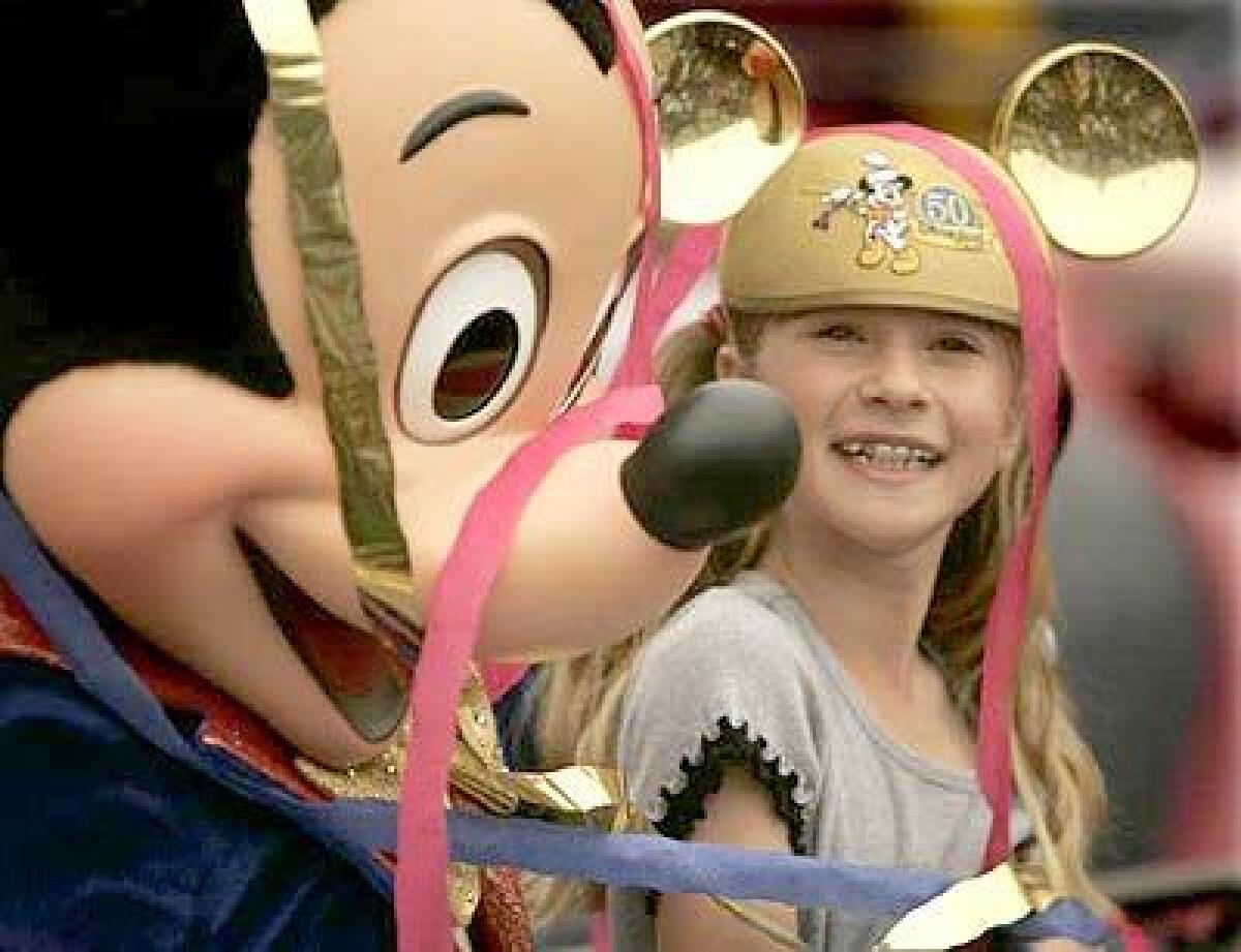 Caroline Sunshine of Orange County gets a hug from Mickey in May as the park began gearing up for its 50th birthday. The park has been updating fireworks and parades, adding attractions and painting, painting, painting.