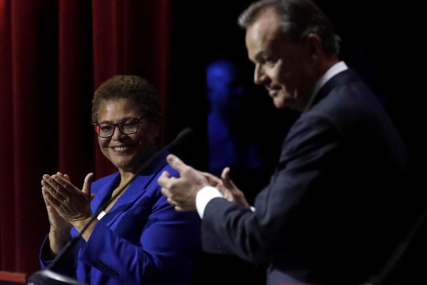 Karen Bass and Rick Caruso before the start of a mayoral debate in March.