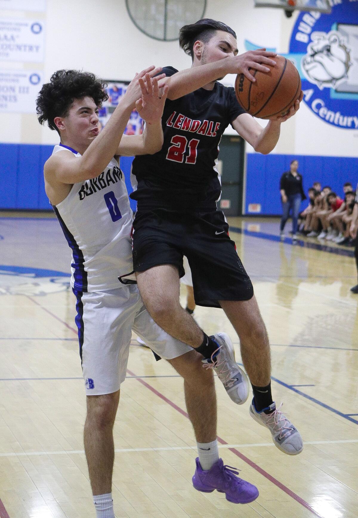 Glendale High's Manouk Manoukian comes down with a rebound over Burbank's J.G. Lambert in Friday's Pacific League game.