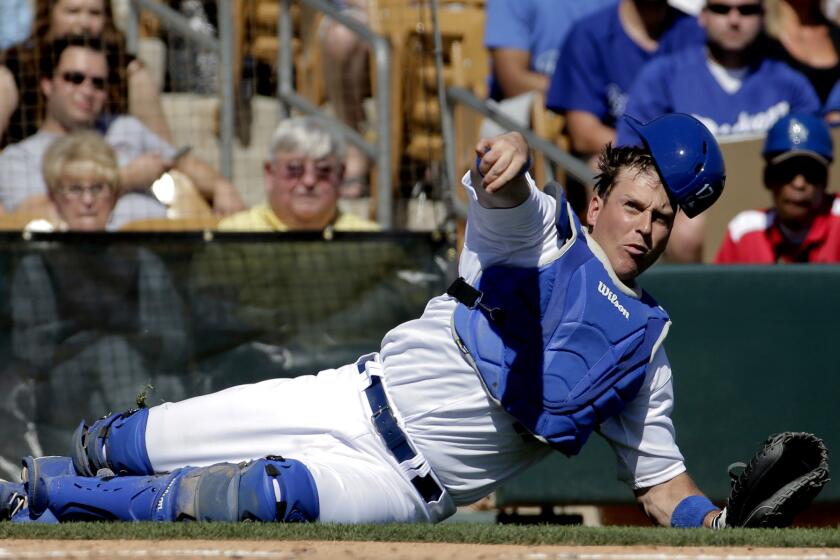 Dodgers catcher A.J. Ellis tries to throw to first base to put out Milwaukee's Elian Herrera, who was safe in the third inning.