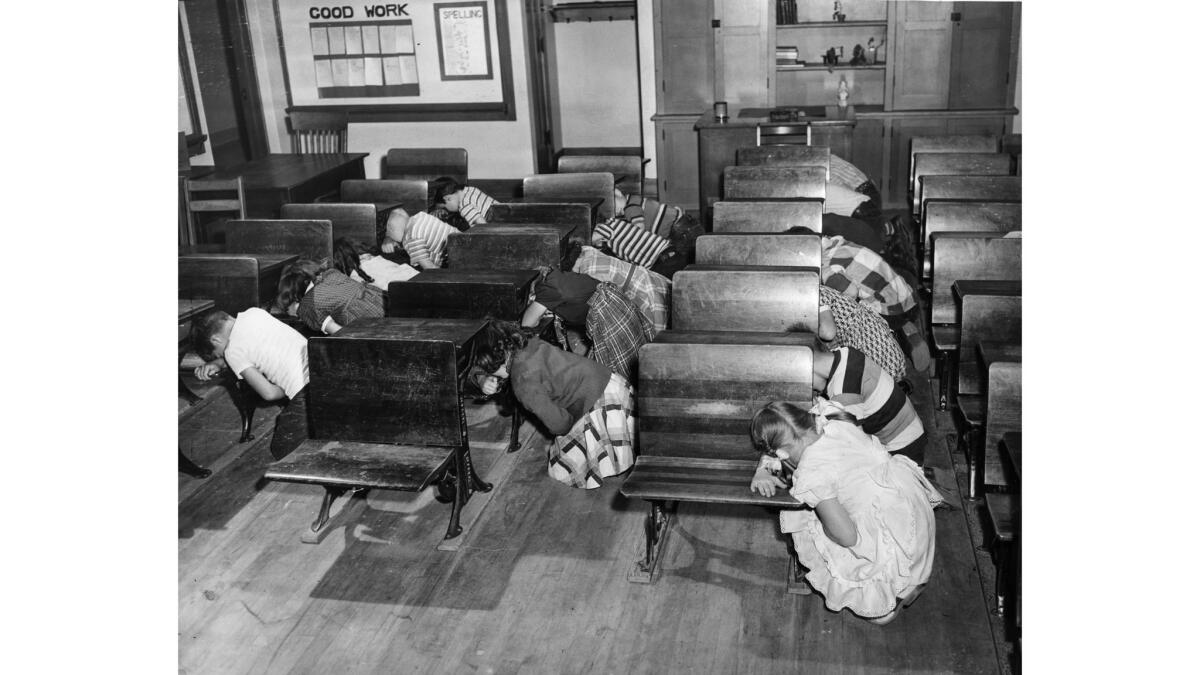 Dec. 1, 1950: Third-graders at Clifford Street School kneel at desks and cover their faces and eyes with their arms during a civil defense drill.
