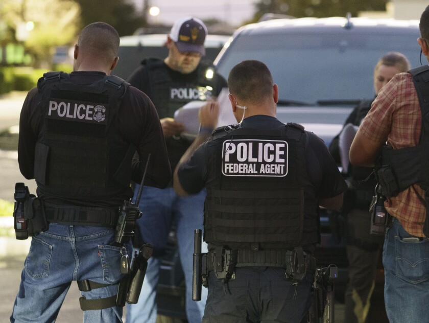 U.S. Immigration and Customs Enforcement agents gather before a raid to arrest immigrants considered a threat to public safety and national security during an early morning raid in Compton, Calif., Monday, June 6, 2022. This weekend, the Biden administration said it would suspend an order prioritizing the arrest and deportation of immigrants considered a threat to public safety and national security in order to comply with a ruling earlier in June 2022 from a Texas judge. Many otherwise law-abiding immigrants living here illegally will now be afraid to leave their homes out of concern they'll be detained. (AP Photo/Damian Dovarganes)