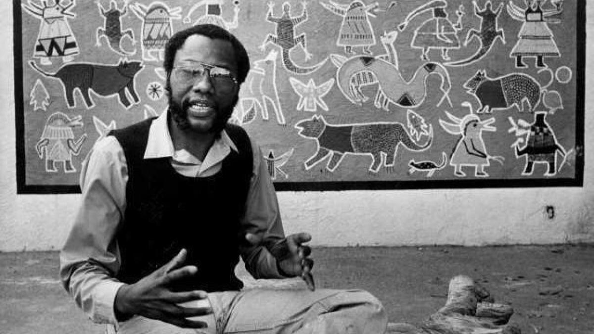 John Otterbridge sits with a creation at the African American Doll Exhibition