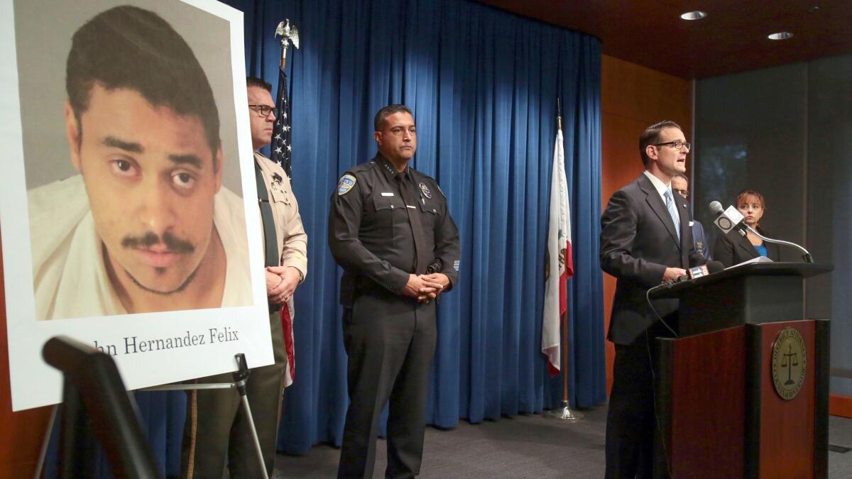 Riverside County Dist. Atty. Mike Hestrin, at podium, at a press conference Oct. 12 announcing he was charging John Felix with killing two Palm Springs police officers.