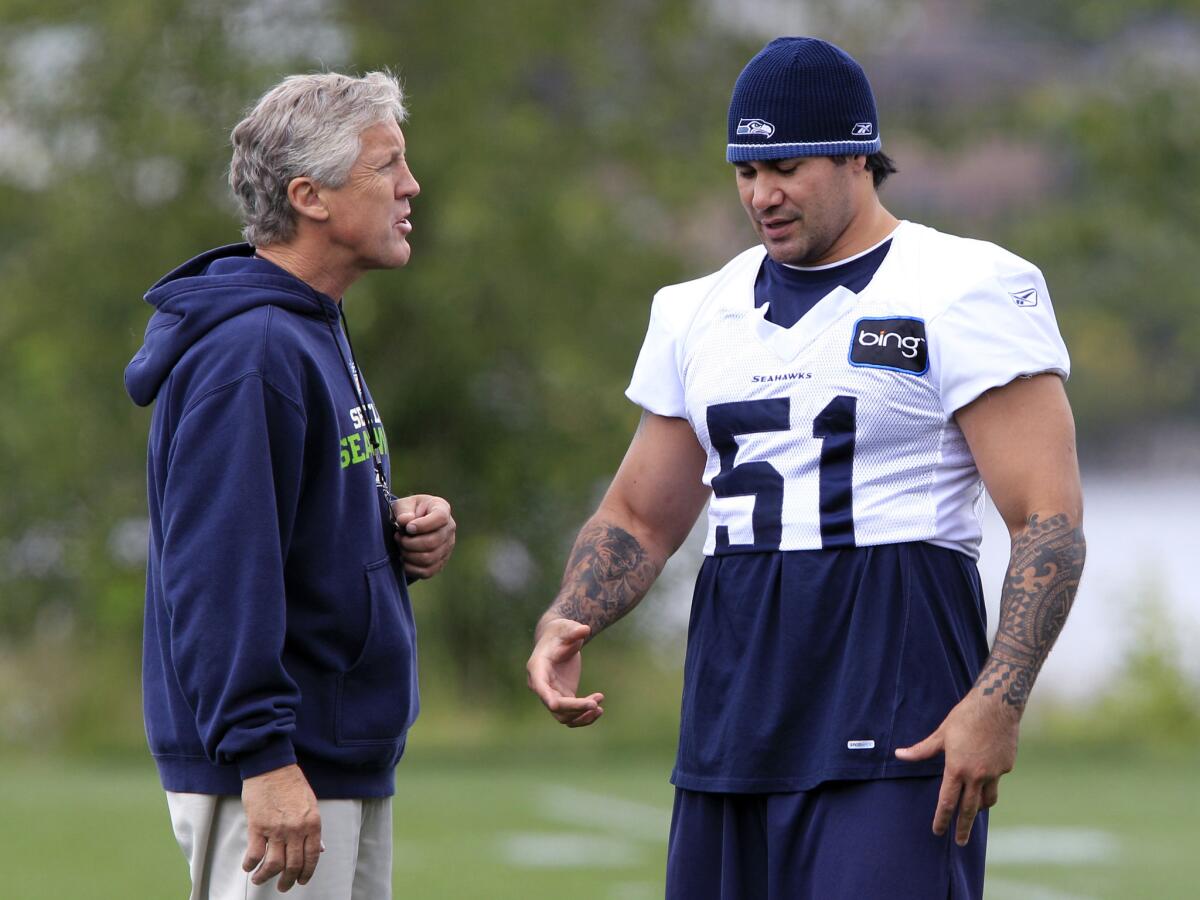 Former USC and Seattle Seahawks linebacker Lofa Tatupu, right, has been hired by Seahawks Coach Pete Carroll, left, to be an assistant linebackers coach.