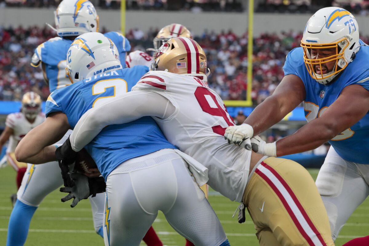 Chargers offensive tackle Trey Pipkins (79) whiffs on a block as quarterback Easton Stick is sacked for a safety 