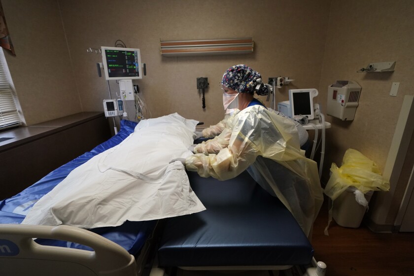 FILE - Medical staff move a COVID-19 patient who died onto a gurney to hand off to a funeral home van, at the Willis-Knighton Medical Center in Shreveport, La., Aug. 18, 2021. The U.S. death toll from COVID-19 topped 800,000, a once-unimaginable figure seen as doubly tragic, given that more than 200,000 of those lives were lost after the vaccine became available practically for the asking. (AP Photo/Gerald Herbert, File)