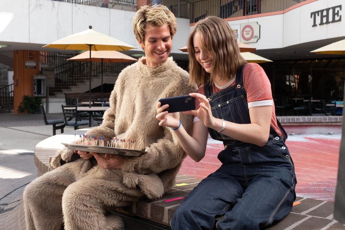 Andrew Garfield and Maya Hawke share a laugh in a scene from "Mainstream."
