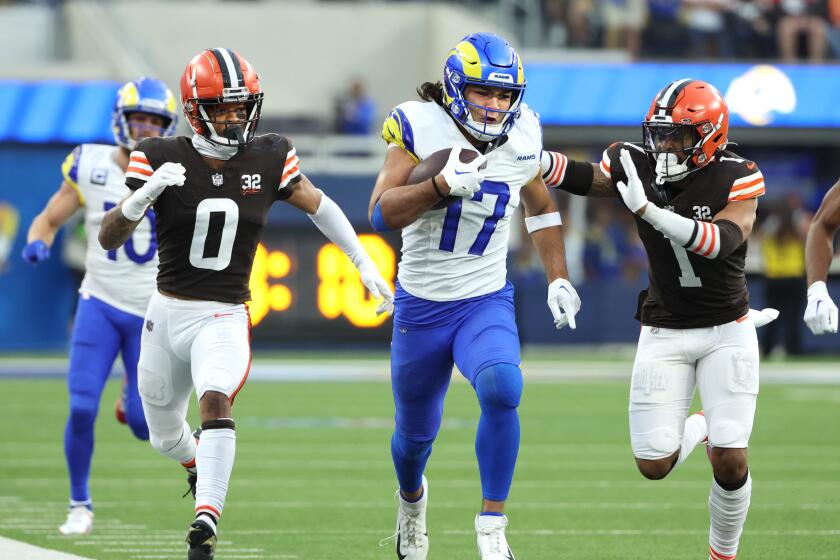 Browns Greg Newsome (0) and Juan Thornhill try to catch Rams receiver Puka Nacua.