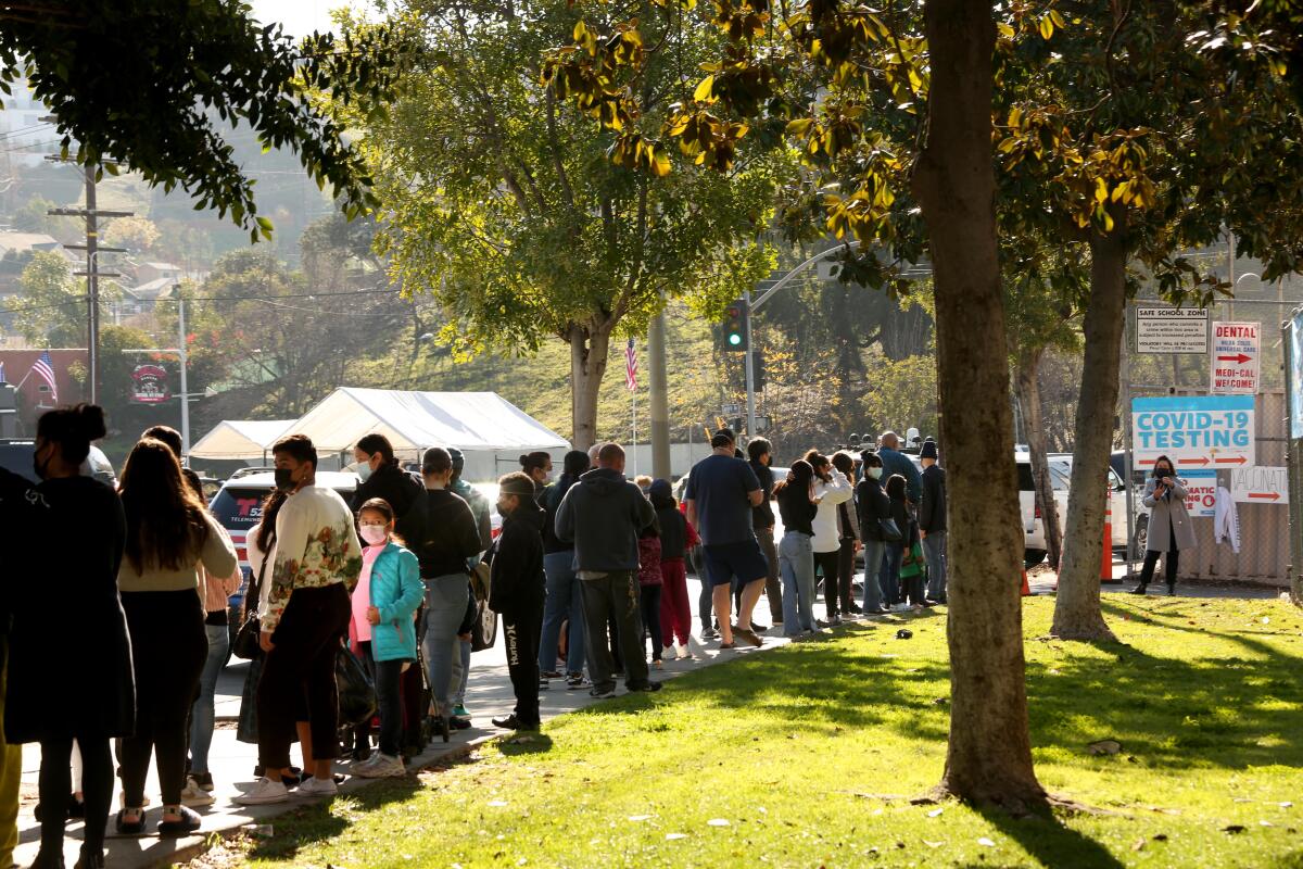 People wait in line for a COVID-19 test at a walk-up site at El Sereno Middle School on Jan. 4.