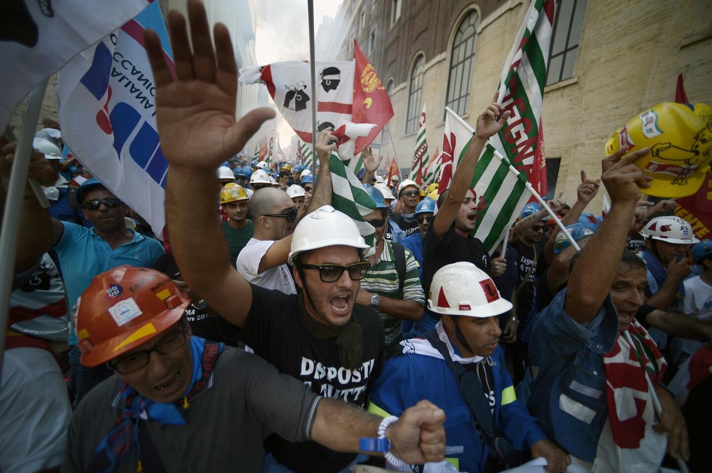 Employees of Alcoa, one of the world's leading producers of aluminum, shout slogans as they take part in a demonstration outside the industry ministry in Rome.