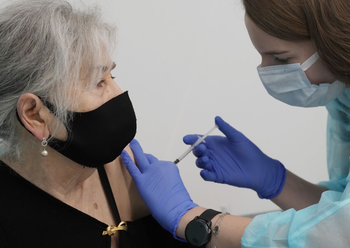 FILE - Hanna Zientara, an 83-year-old resident of Warsaw, receives a booster shot against COVID-19, in Warsaw, Poland, on Dec. 7, 2021. Poland has become the latest European nation to reach the grim milestone of 100,000 deaths related to the coronavirus. Nearly a quarter of those deaths — some 24,000 — occurred in the most recent wave of infection that began in October, a period in which vaccines have been widely available in the European Union nation. (AP Photo/Czarek Sokolowski)