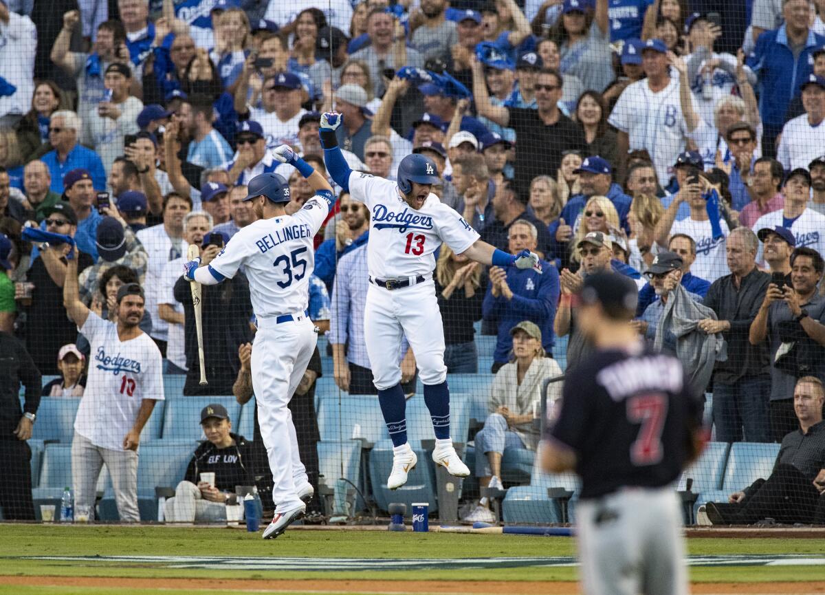 Dodgers first baseman Max Muncy (13) celebrates with on-deck batter Cody Bellinger (35) after Muncy hit a 2-run homer off the Washington Nationals in the first inning of Game 5 of the NLDS at Dodger Stadium on Oct. 9, 2019.