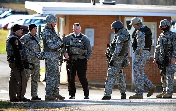 Local S.W.A.T. team members congregate near a parking lot on the campus of Virginia Tech to look for an armed man who is suspected of killing two people, Thursday, Dec. 8, 2011, in Blacksburg, Va.