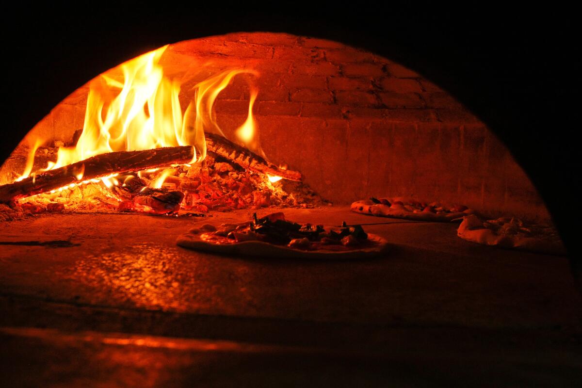Pizzas bake for 60 to 90 seconds at around 850 degrees inside a handmade wood-burning oven imported from Naples, Italy, at Mother Dough pizzeria in Los Feliz.