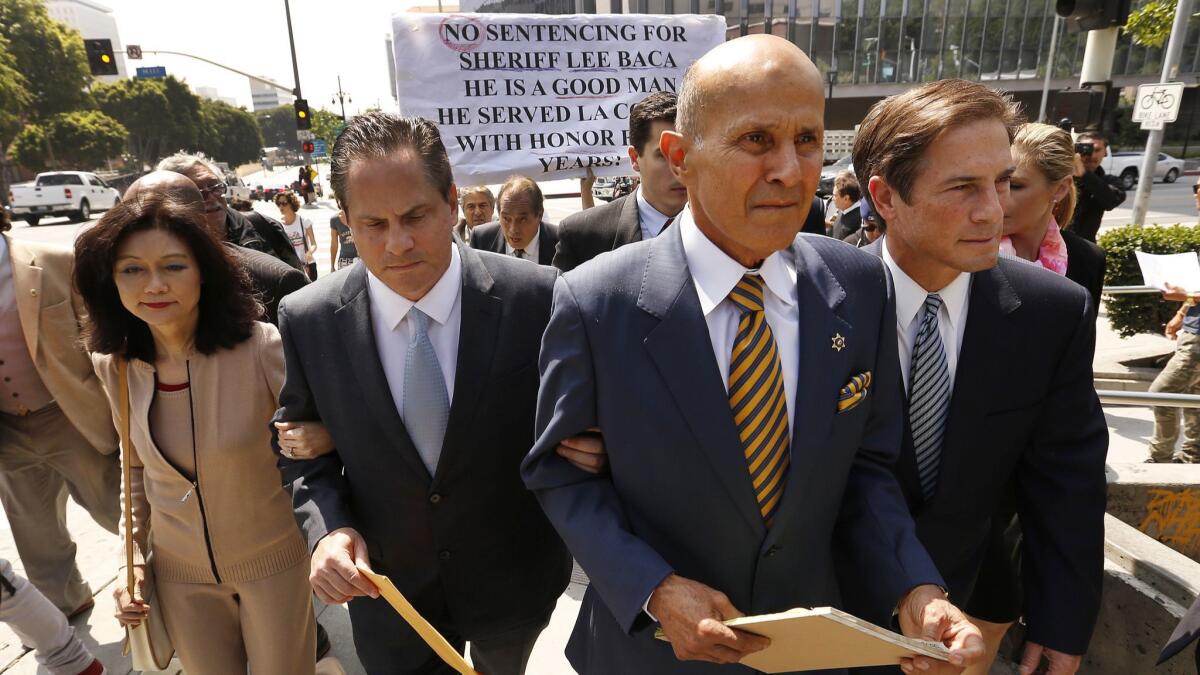 Former L.A. County Sheriff Lee Baca, second from right, leaves federal court last year. Baca was found guilty of obstruction of justice, conspiracy and making false statements in connection with an effort to obstruct an FBI probe into corruption and brutality by jail deputies.