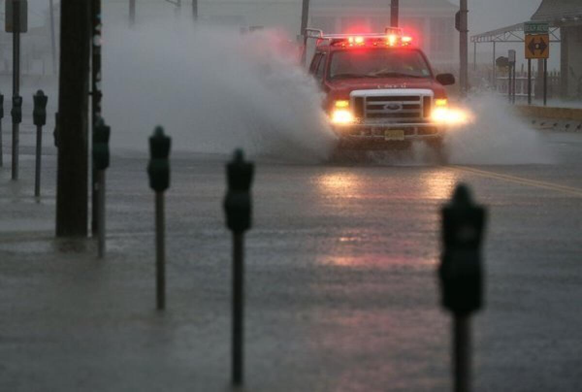 An emergency vehicle drives down an avenue flooded by Hurricane Sandy on Oct. 29 in Cape May, N.J.