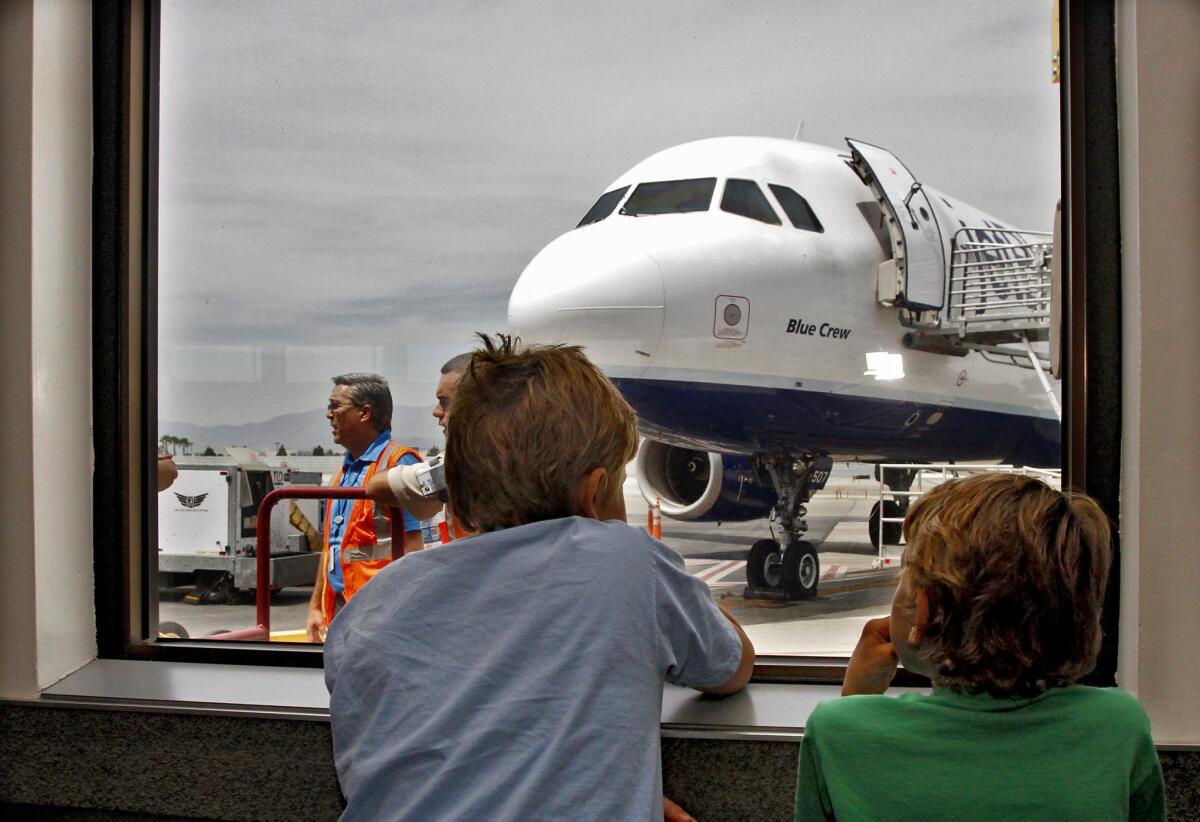 Aberdeen Crabb, 10 of Glendale, left, waits to board a commercial airliner the Blue Horizons for Autism event sponsored by Jet Blue Airways, Autism Speaks and the TSA at Bob Hope Airport in Burbank on Saturday, May 3, 2014.