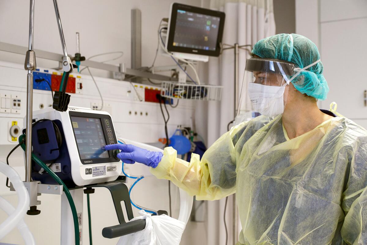 A doctor in Israel checks a medical ventilator control panel while wearing protective clothing. Hospitals worldwide are bracing for the impact of the coronavirus, and the U.S. is short on supplies.