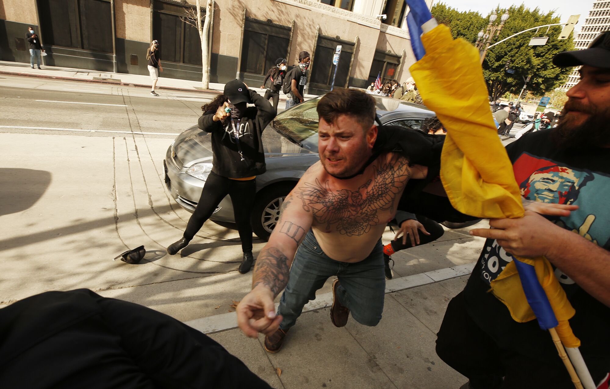 A Trump supporter, right, is punched and sprayed by counterprotesters.