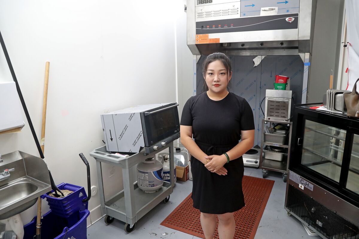 Little Pan Fried Bun owner Vicky Liu stands in her unfinished eatery at the Union Market in Tustin on Aug. 11.