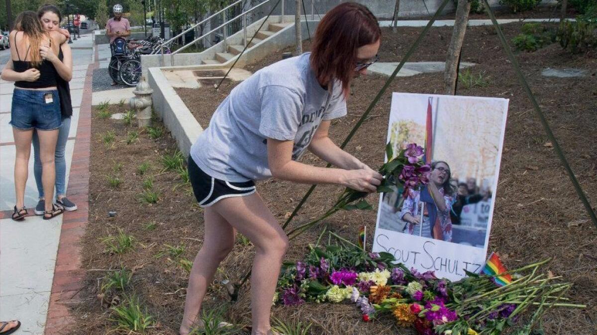 A mourner sets out flowers at a memorial for Georgia Tech student Scout Schultz in Atlanta.