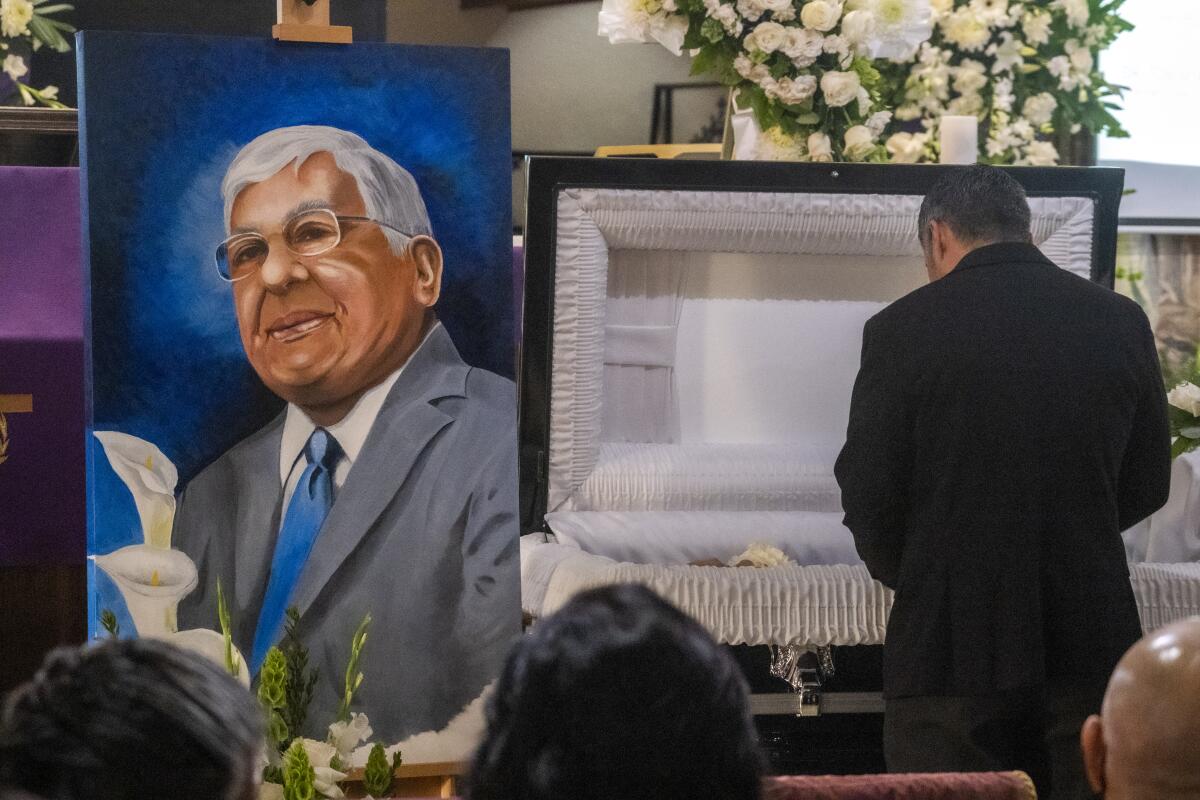 A painting of Tom Rivera sits next to a coffin at San Salvador Church in Colton.