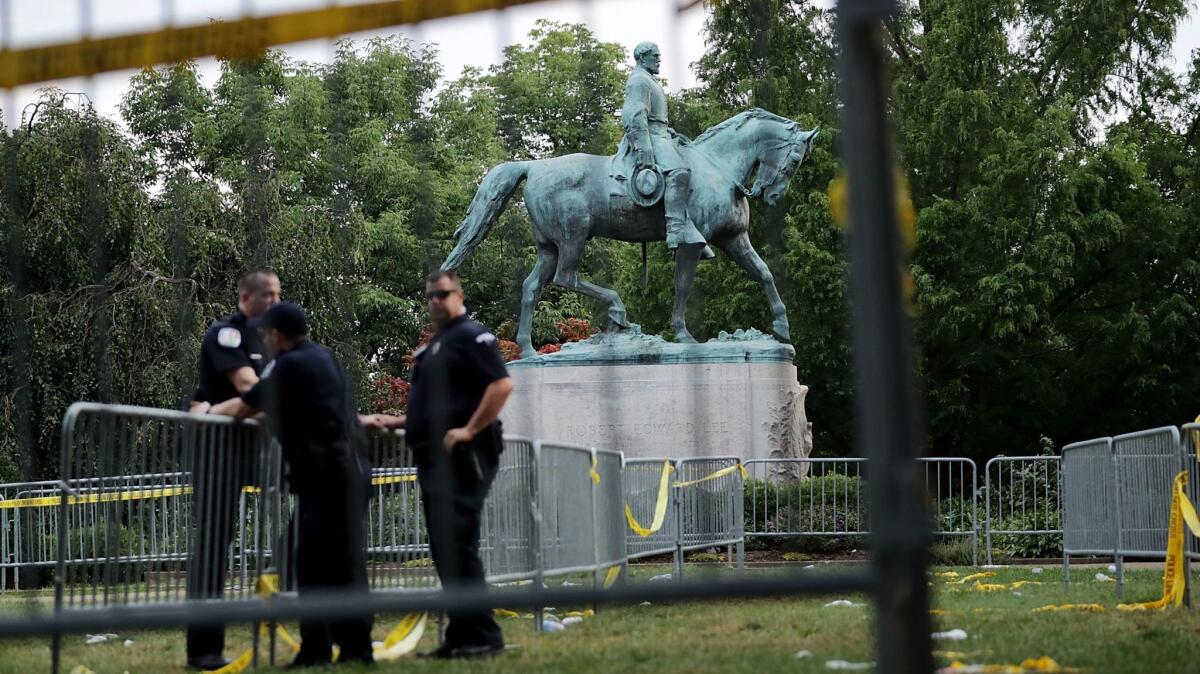 Police stand watch near the statue of Robert E. Lee in Emancipation Park in Charlottesville, Va., on Aug. 13.