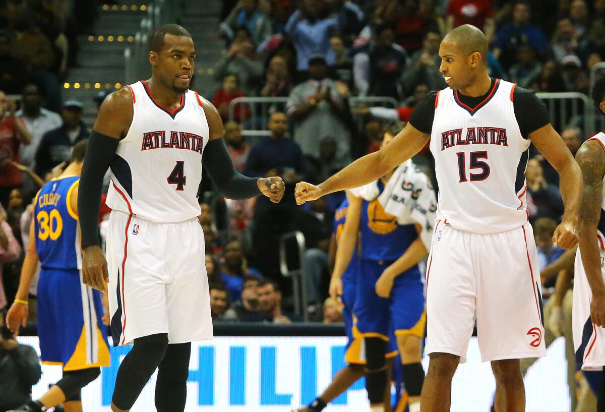 Hawks big men Paul Millsap (4) and Al Horford (15) share a fist bump after a bucket in the Hawks' 124-116 win over the Warriors, the top-seeded Western Conference team.