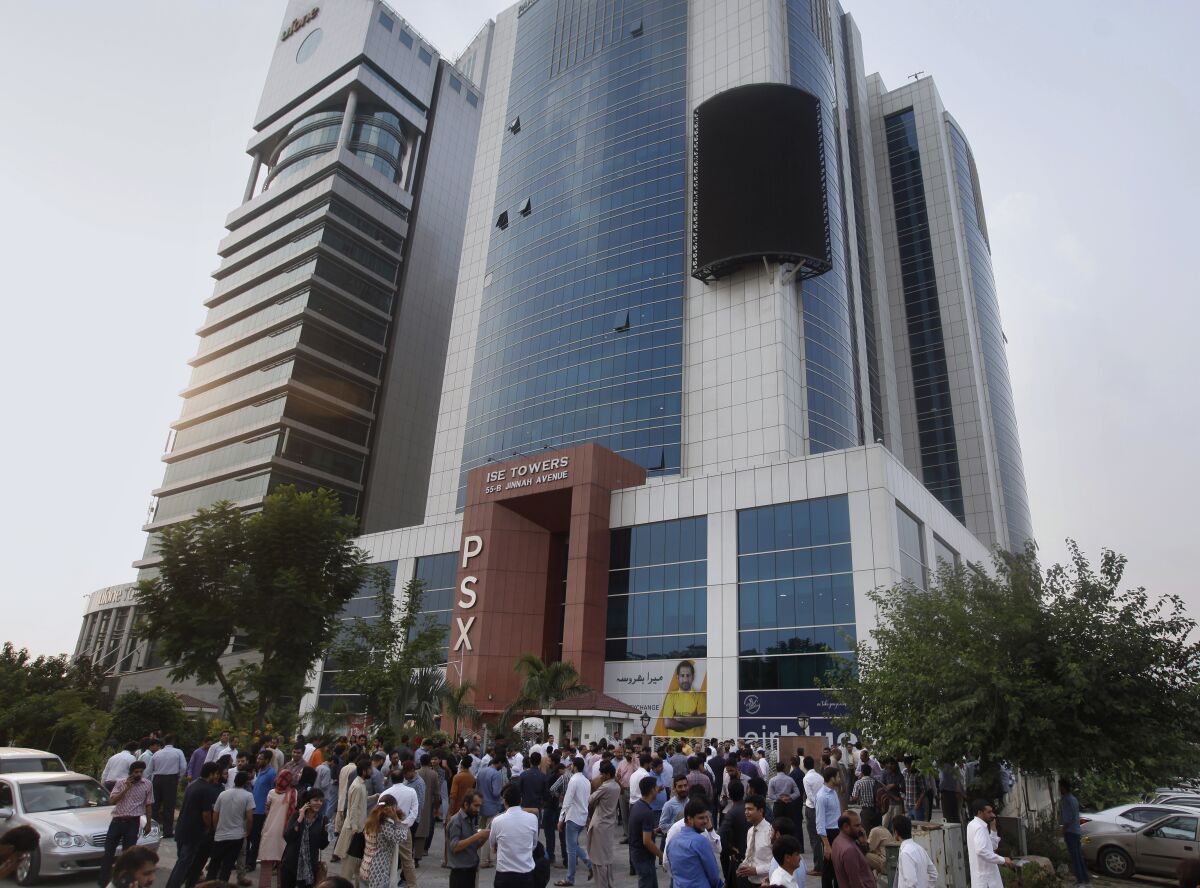People gather outside their office building after an earthquake is felt in Islamabad, Pakistan, on Tuesday.