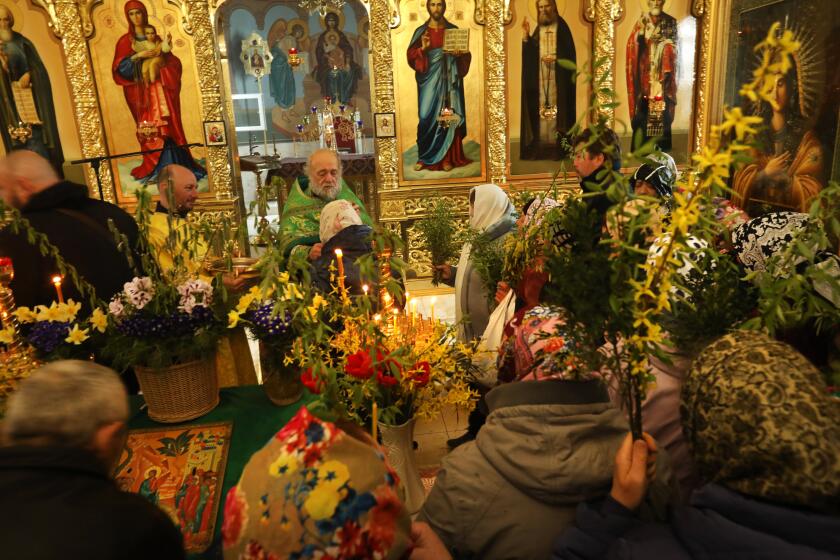 Slavyansk, Ukraine-APRIL 17, 2022-Priest Valeri Lebed blesses these attending Palm Sunday service at the Serafim Sarovsky Orthodox Church on the outskirts of Slavyansk, Ukraine on April 17, 2022. About 100 parishioners attended and many said they attended to calm their nerves about the approaching Russian forces. (Carolyn Cole / Los Angeles Times)