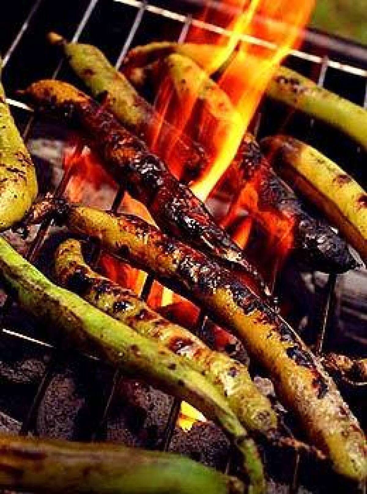 Fava pods grilled over smoldering coals steam in their husks. They make a satisfying finger food.