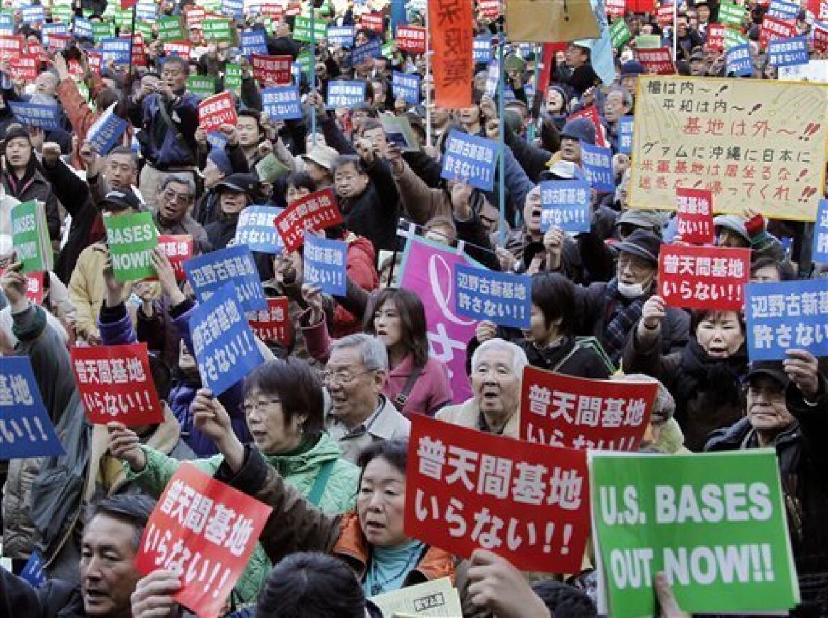 Demonstrators hold up anti-U.S. bases slogans as some 6,000 people gather at a rally protesting against a U.S. Marine base stationed on the southern island of Okinawa, in Tokyo Saturday, Jan. 30, 2010. Japanese Prime Minister Yukio Hatoyama said Friday he would decide by the end of May on where to relocate the U.S. Marine Airfield Futenma in Okinawa that has strained ties between the nations. The slogans written in Japanese read: "We don't need Futenma base," in red, and "We refuse new Henoko base," in blue. (AP Photo/Koji Sasahara)